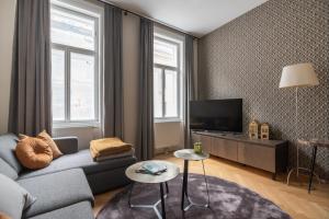ein Wohnzimmer mit einem Sofa und einem TV in der Unterkunft Hochwertiges Apartment mit direkter Anbindung zum Zentrum in hippen Viertel in Wien
