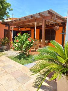 a house with a wooden pergola and a patio at CASA DA BARRA- Suítes privativas em Saquarema in Saquarema