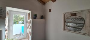 Habitación con ventana y una foto en la pared. en Beautiful house in stunning nature, 22 minutes from beaches, 5 minutes to lake, air condition cool and heat, and very fast Internet in all rooms, dishwasher, washing machine and induction cooking, en Silves