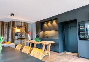 a dining room with a wooden table and chairs at Luxe vakantiewoning, Maison Masko, tussen Brugge en Oostende in Jabbeke