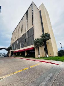 a large building with palm trees in front of it at DoubleTree by Hilton Laredo in Laredo