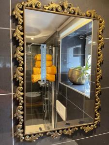 a mirror on a wall with some yellow towels at Sweet Home in Murten