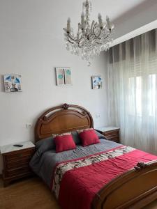 Un dormitorio con una gran cama de madera con almohadas rojas en Arenales 8 en Pobra do Caramiñal