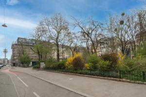 an empty street with trees and bushes and a building at Ruhiges Apartment in 15 Min zum Zentrum in Vienna