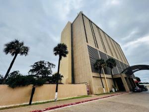 a building with palm trees in front of it at DoubleTree by Hilton Laredo in Laredo +5 photos