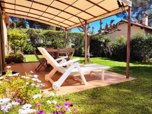 a pair of chairs and a table under a pergola at Côté Jardin - T2 avec Terrasse Couverte et Jardin in Cassis