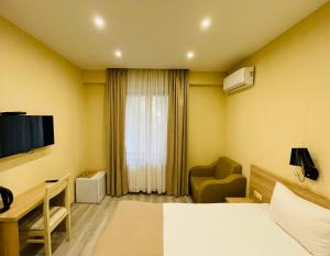 Cette chambre comprend un lit, un bureau et une télévision. dans l'établissement Bliss Hotel, à Tbilissi