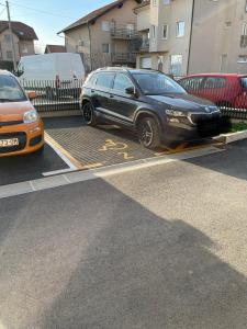 une voiture noire est garée dans un parking dans l'établissement Tadea Apartment Zagreb, à Zagreb