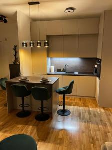 - une cuisine avec deux tabourets de bar et un comptoir dans l'établissement Tadea Apartment Zagreb, à Zagreb