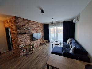 a living room with a couch and a brick wall at Schneidemühl Premium Apartments in Piła