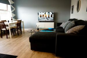 uma sala de estar com um sofá e uma mesa em Wonderful apartment with beautiful natural pearls. em Bifrost
