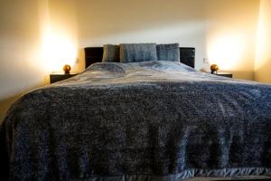 um quarto com uma cama grande e um cobertor azul em Wonderful apartment with beautiful natural pearls. em Bifrost