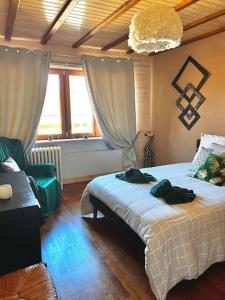 ein Schlafzimmer mit einem Bett, einem Stuhl und einem Fenster in der Unterkunft Le Passage du Faubourg, agréable T3 en duplex de 120m2 in Saint-Léonard-de-Noblat