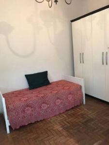 a bedroom with a bed with a red comforter at Bucolico Apartamento em Copacabana in Rio de Janeiro
