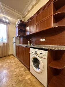 a kitchen with a washing machine and wooden cabinets at Nice Apartment in Koghbaci Street in Yerevan
