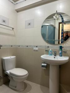 a bathroom with a toilet and a sink and a mirror at Nice Apartment in Koghbaci Street in Yerevan