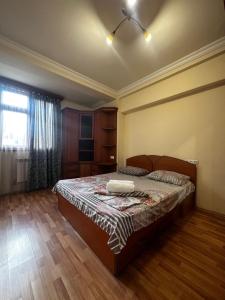 a bedroom with a bed and a large window at Nice Apartment in Koghbaci Street in Yerevan