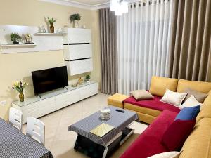 a living room with a couch and a tv at Queen Isabella Premium in Vlorë