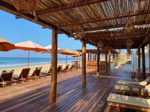 a deck with chairs and umbrellas on a beach at Hotel Estrella de Mar in Zipolite