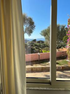 a window with a view of a garden at B&B Isola Mia in La Maddalena