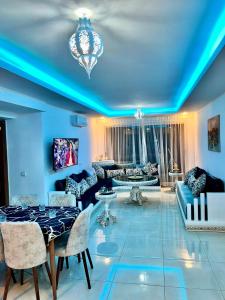 sala de estar con techos azules, mesa y sillas en The blue pearl-Sensational beach apartment in Aourir en Agadir