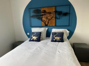 a bedroom with a bed with two blue and white pillows at Maison Les Géraniums in Mers-les-Bains
