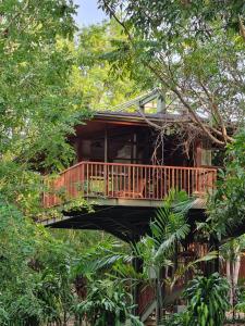 a tree house with a deck in the trees at Grün Resort Uluwatu in Uluwatu