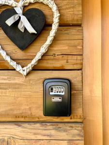einem digitalen Thermometer an einer Holzwand mit einem Herz in der Unterkunft Apartmani Lara&Sara in Bihać