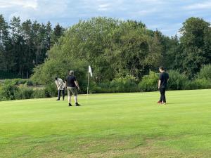 3 Männer spielen eine Partie Golf auf einem Golfplatz in der Unterkunft Goldener Anker Pottenstein Urlaub für die ganze Familie in Pottenstein