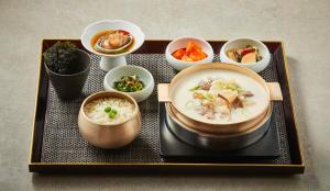 a tray with a plate of soup and bowls of food at Roynet Hotel Seoul Mapo in Seoul