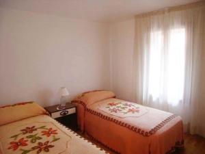 1 Schlafzimmer mit 2 Betten und einem Fenster in der Unterkunft Calle Burchio in Grado