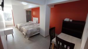 una camera con letto, scrivania e TV di Hotel Santa Maria a Ica