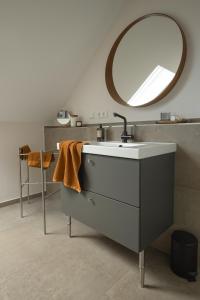 een badkamer met een wastafel en een spiegel bij Haus 1 in Bosau