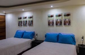 two beds in a room with paintings on the wall at Casa Irma in Guatemala