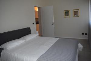 a bedroom with a white bed with white sheets at MyVilla - Ivrea via Jervis 22b in Ivrea