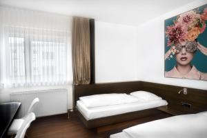 1 dormitorio con 1 cama y una pintura en la pared en Stadthotel Heilbronn en Heilbronn