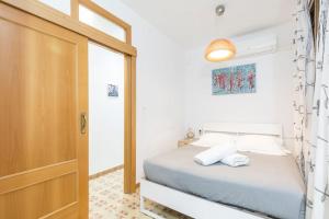Habitación pequeña con cama y puerta en Art Apartment, en Barcelona