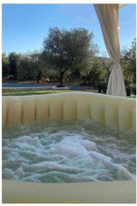 una vasca idromassaggio con acqua all'interno con alberi sullo sfondo di L'oliveto a Nuxis