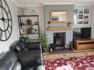 a living room with a leather couch and a fireplace at Self-catering in Portree in Portree