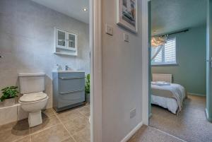 a bathroom with a toilet and a sink and a bed at CAPRI 13 SA - Contemporary 2 bedroom house in Loughborough with free parking, Close to Loughborough University & M1 Motorway in Loughborough +33 photos