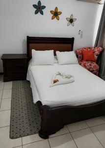 Un dormitorio con una cama con dos zapatos. en Casa de playa con piscina y jacuzzi privado en Puntarenas