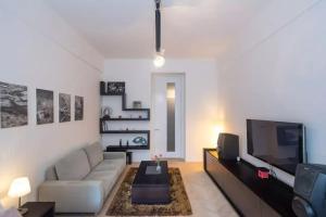 een woonkamer met een bank en een flatscreen-tv bij Old Town Square Luxury Apartment in Praag