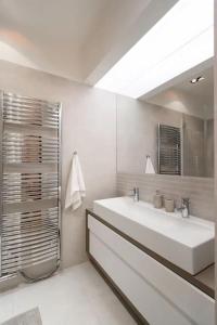 bagno bianco con lavandino e specchio di Old Town Square Luxury Apartment a Praga