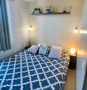 een slaapkamer met een bed met een blauw en wit dekbed bij mobil home "AMBRE" 6p, CLIM&TV in Vic-la-Gardiole