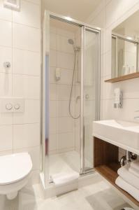 a bathroom with a shower and a toilet and sink at Garden Hotel in Nürnberg