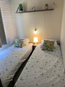 een kleine kamer met 2 bedden en een lamp bij mobil home "AMBRE" 6p, CLIM&TV in Vic-la-Gardiole