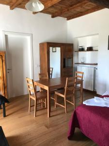 comedor con mesa de madera y sillas en Appartamento La Camelia, en Ameno