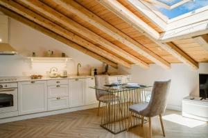 a kitchen with white cabinets and a glass table at Cambiello Bella Casa in Corfu Town