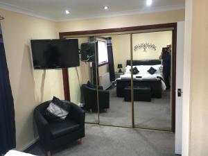 a room with a mirror and a bed and a tv at Highland Home in Fort William