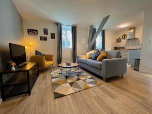 uma sala de estar com um sofá e uma mesa em Nid douillet T2 rénové climatisé centre em Brive-la-Gaillarde